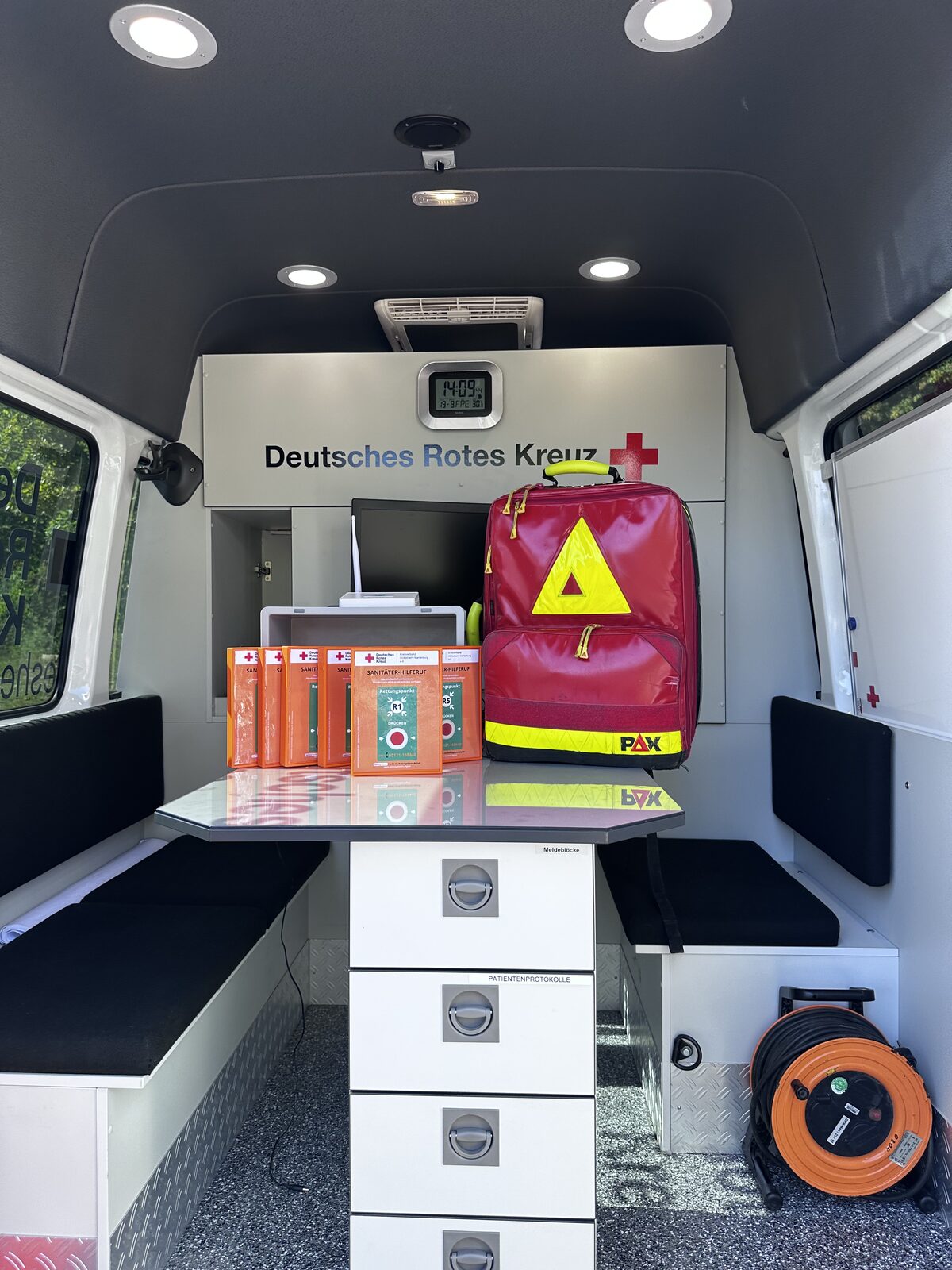Innenraum des DRK-Einsatzleitwagens mit Arbeitsplatz und Notfallrucksack